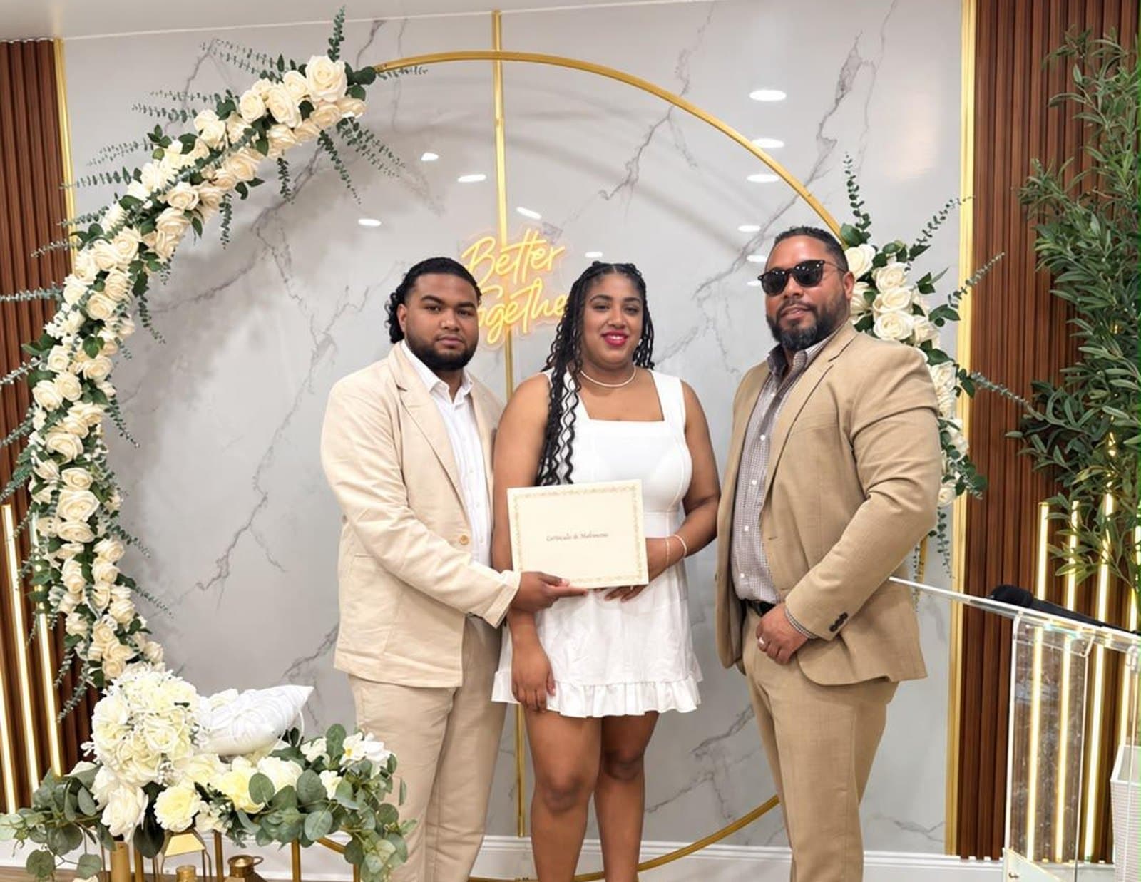 Pareja con su certificado de matrimonio junto al oficiante