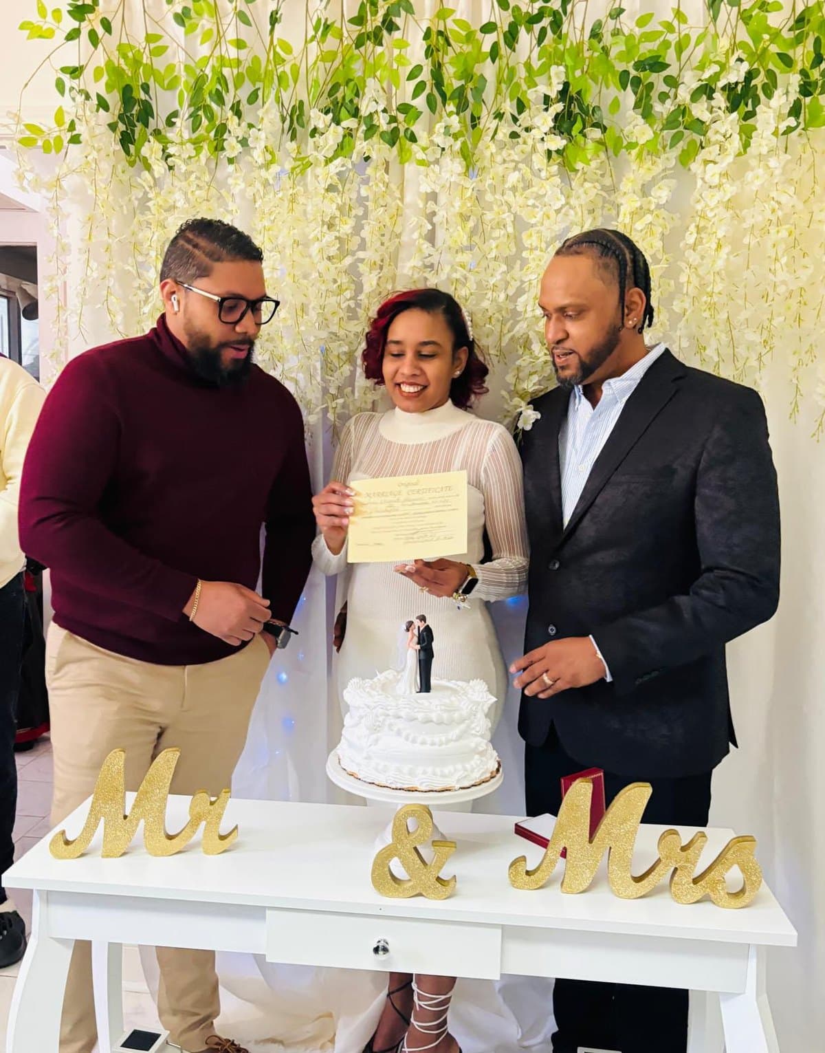 Pareja con su certificado frente a la cortina de glicinias